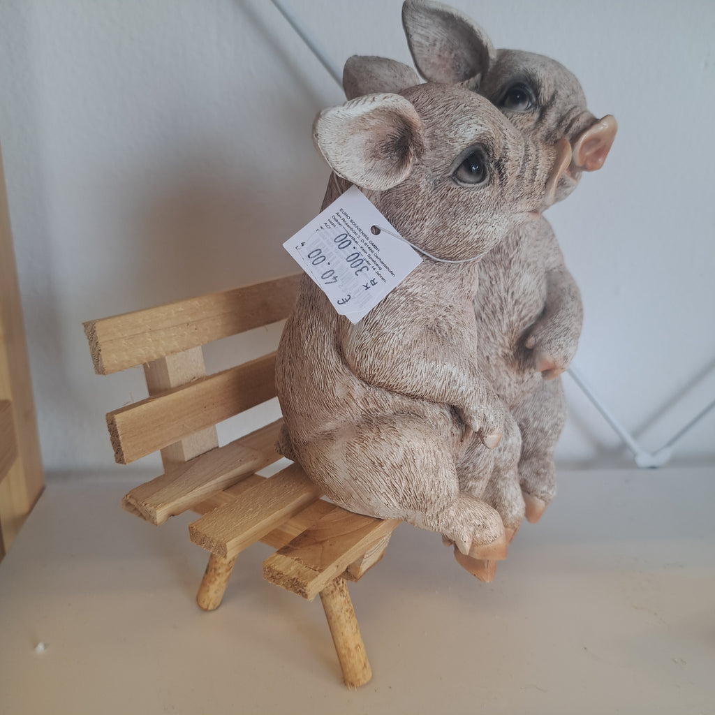 Gris figur på bænk – humoristisk og hyggelig dekoration